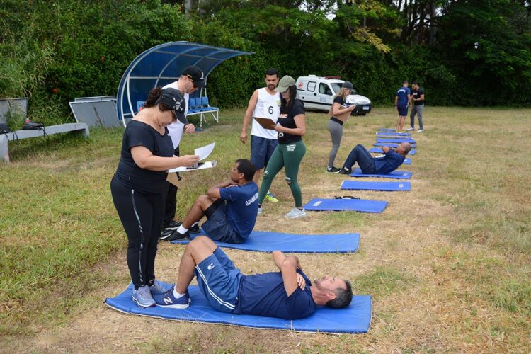 Como será o TAF no concurso da GCM Maceió 2026? Descubra agora 1 Candidatos fazendo abdominais sob avaliação de fiscais durante teste físico ao ar livre