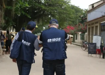 Recenseadores do IBGE coletando informações em área urbana durante trabalho de campo do censo.