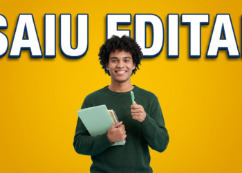 Estudante sorrindo segura cadernos e caneta com fundo amarelo e texto saiu edital