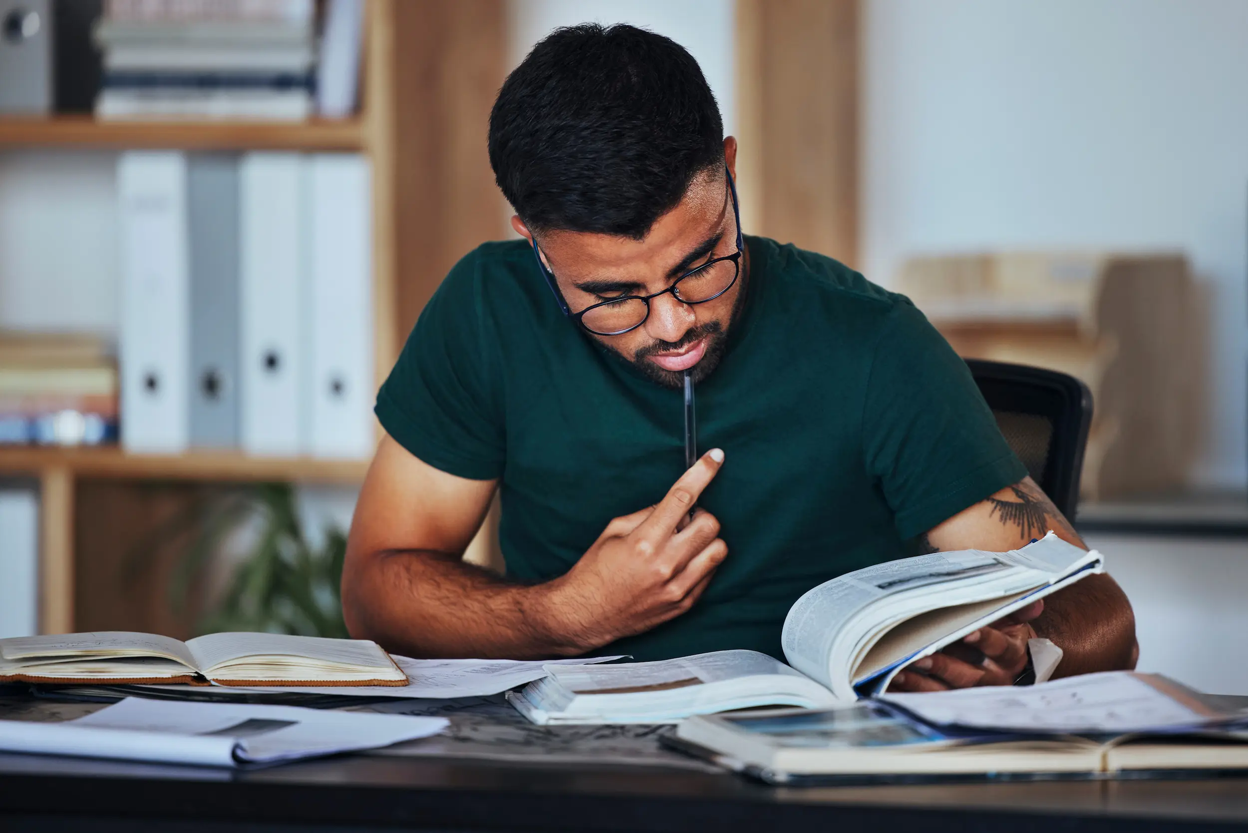 Concurso público em 2026: nunca houve tantos motivos para deixar a CLT de lado (veja quais são eles) 2 Candidato estudando para concurso público analisando livro e materiais de estudo em busca de estabilidade e benefícios da carreira pública.