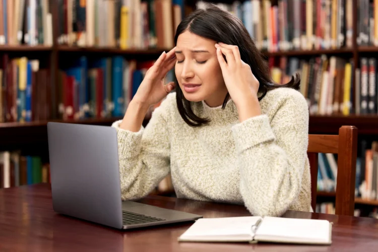 Estuda e esquece tudo? Essas estratégias vão mudar seu desempenho nos estudos para concursos 1 Estudante revisando conteúdo no notebook com expressão de dificuldade de memorização durante preparação para concurso público.