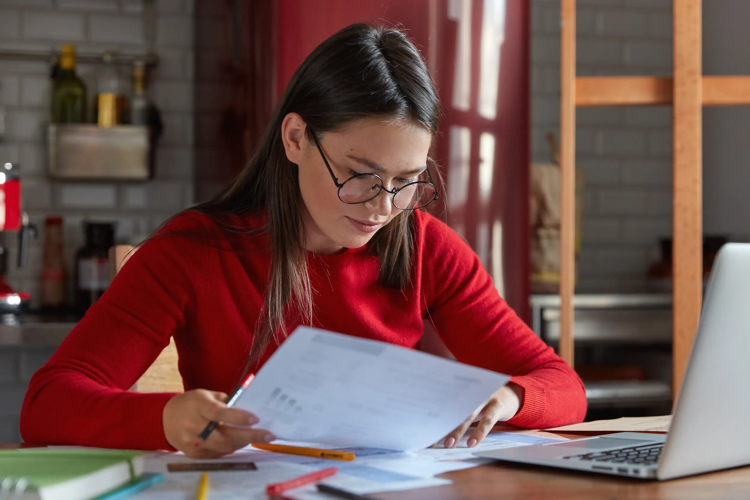 Preparação para o concurso do INSS: por onde começar a estudar 2 Estudante concentrada analisando materiais de estudo enquanto se prepara com foco e disciplina para o concurso do INSS.
