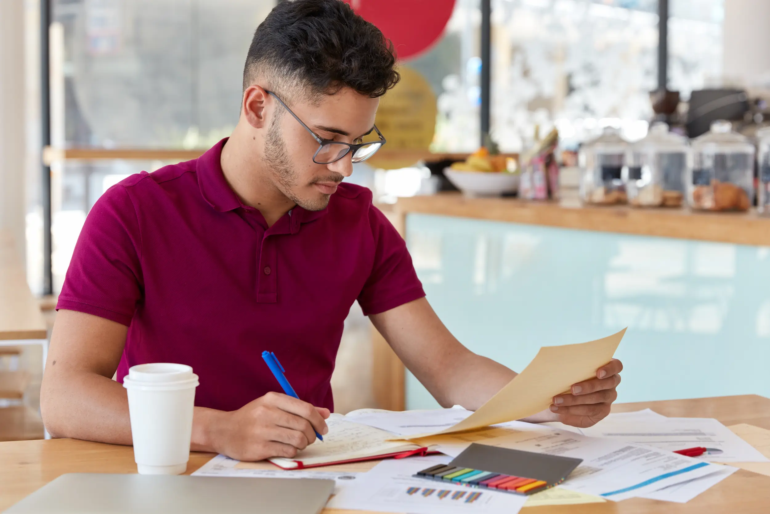Concursos públicos: vale a pena pedir demissão para se dedicar aos estudos? 2 Homem analisando documentos e fazendo planejamento antes de decidir deixar o emprego para estudar para concursos públicos.