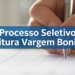 Mão preenchendo cartão-resposta com caneta durante processo seletivo