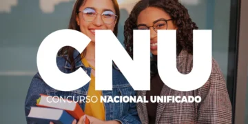 Duas jovens sorriem segurando livros diante de parede de vidro com letras CNU em destaque