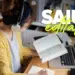 Concurso em São Gonçalo do Rio Abaixo - MG tem vagas para Agente Comunitário de Saúde 9 Mulher de cardigan amarelo e fone estuda em mesa com notebook, livro aberto e texto “SAIU edital!” na tela.
