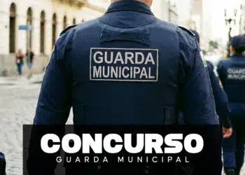 Agentes da Guarda Municipal em uniforme azul-marinho com inscrição nas costas durante patrulhamento urbano