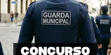 Agentes da Guarda Municipal em uniforme azul-marinho com inscrição nas costas durante patrulhamento urbano