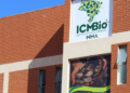 Prédio de tijolos do ICMBio com logotipo verde em forma de mapa do Brasil e painel exibindo mãos com castanhas