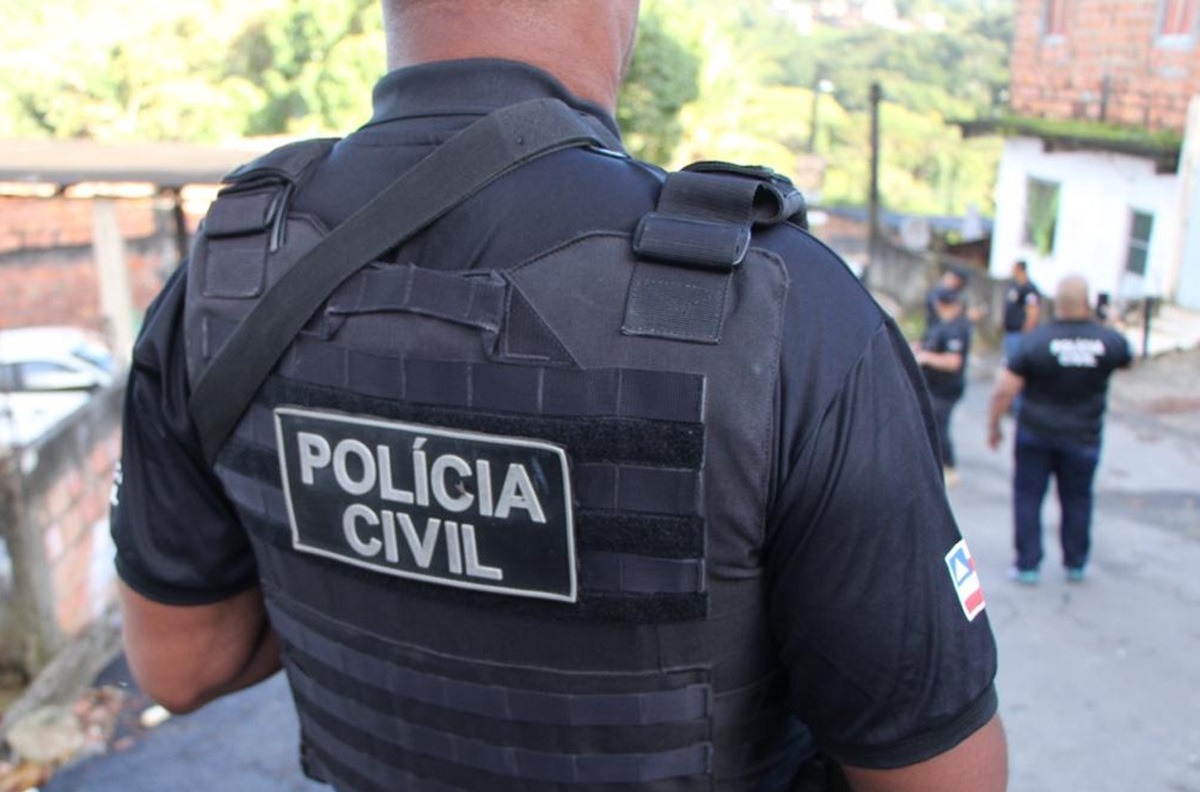 Concurso da Polícia Civil da Bahia está confirmado com 750 vagas; veja o que se sabe 2 Agente da Polícia Civil da Bahia de costas usando colete tático durante operação em área urbana