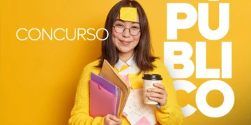 Mulher jovem asiática de suéter amarelo segura pastas, café e post-it na testa, fundo amarelo com texto CONCURSO PÚBLICO.